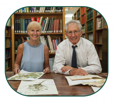 Pam and Doug Soltis at a table with herbarium sheets